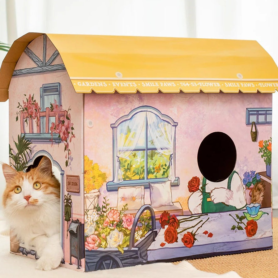 A cardboard flower shop with an orange and white cat leaning out