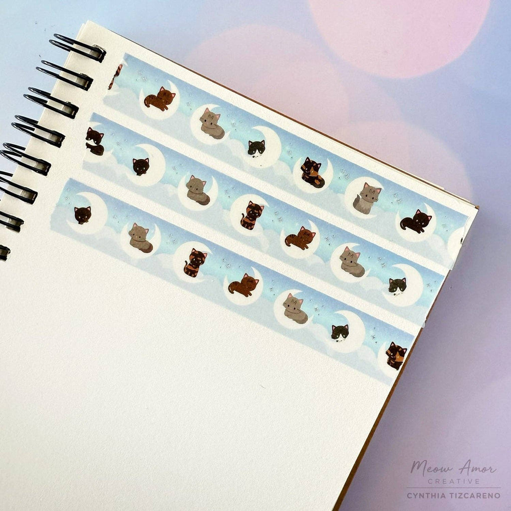 Decorative notebook with cat-themed washi tape on a light background