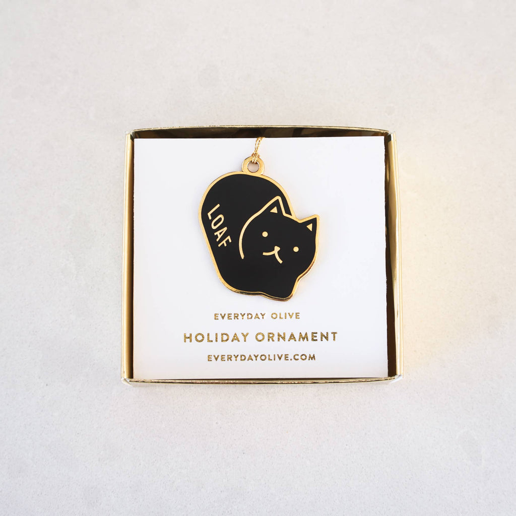 Black cat-shaped ornament with 'LOAF' on a gold and white card against a light gray background