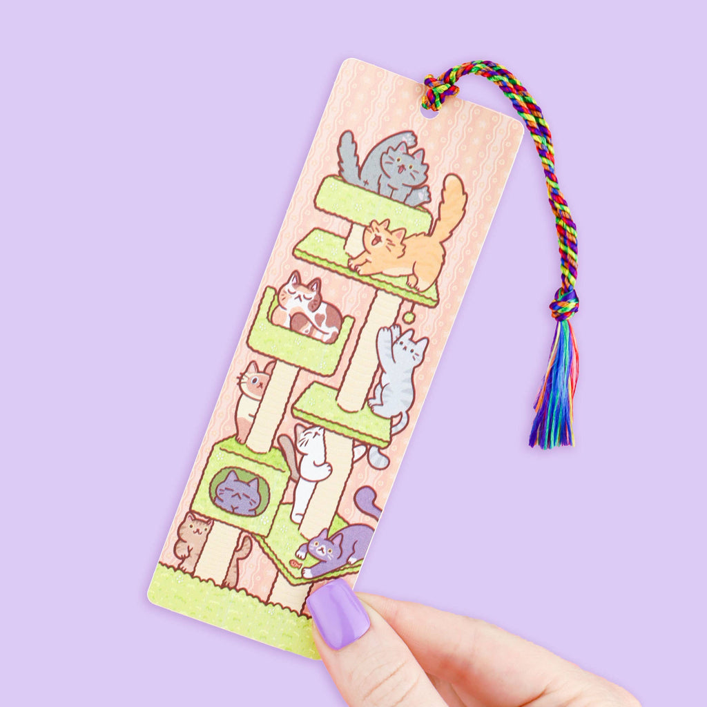 Bookmark with cat illustrations and a colourful tassel on a purple background