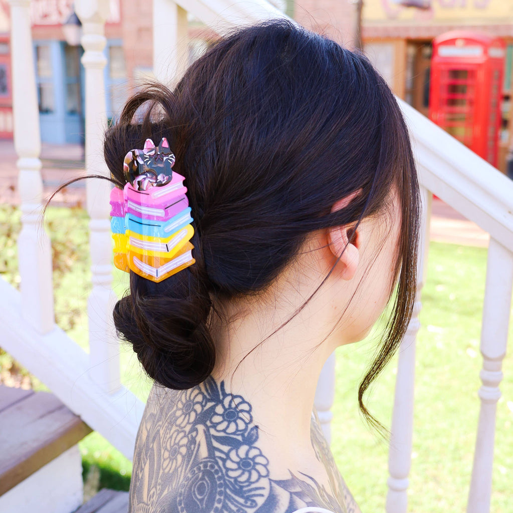 Person with colorful hair tie and tattooed arm outdoors