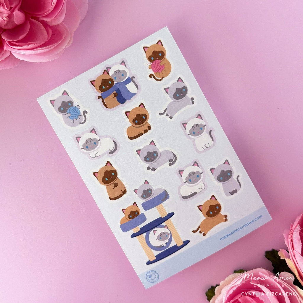 Sheet of cat-themed stickers on a pink background with flowers.