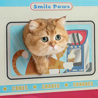 A cat peeking its head out of a cardboard ice cream truck window