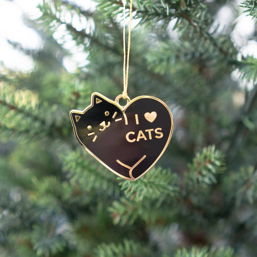 Heart-shaped ornament with a cat design and 'I ❤️ CATS' text hanging on a Christmas tree.