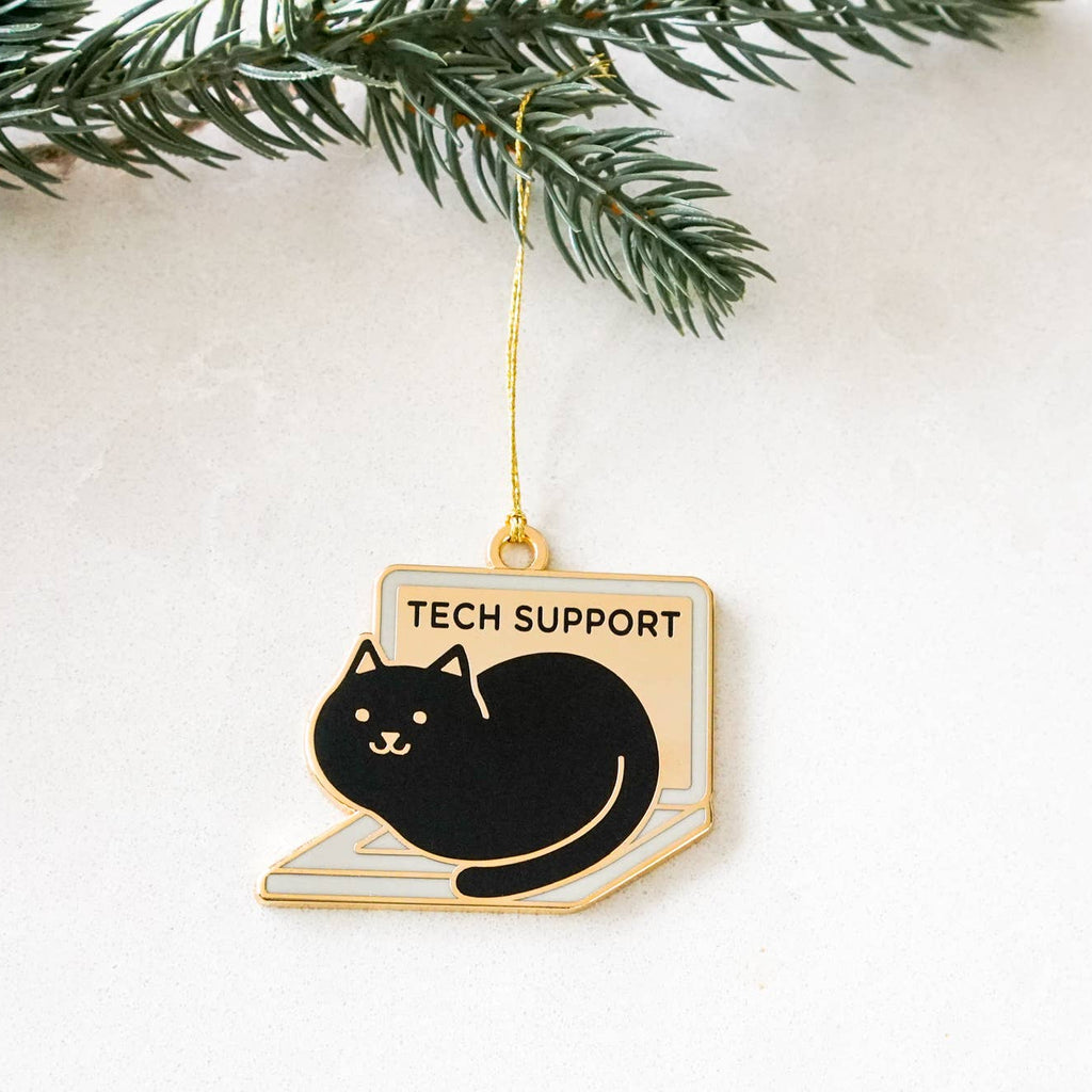 Decorative ornament with a black cat and 'Tech Support' text, hanging from a Christmas tree.