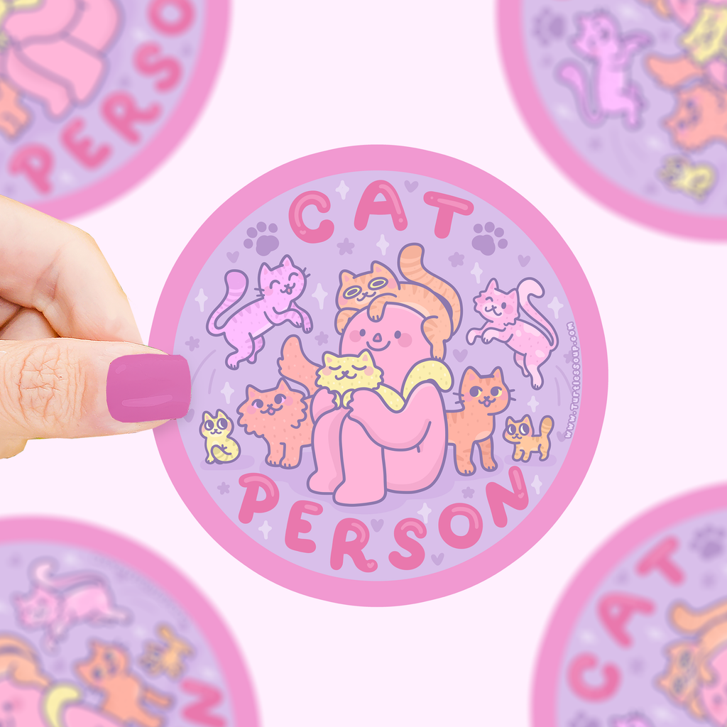 Circular sticker with cartoon cat design and 'Cat Person' text held by a hand.