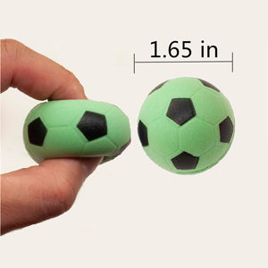 Two green foam soccer balls held by a hand with measurement label '1.65 in'.