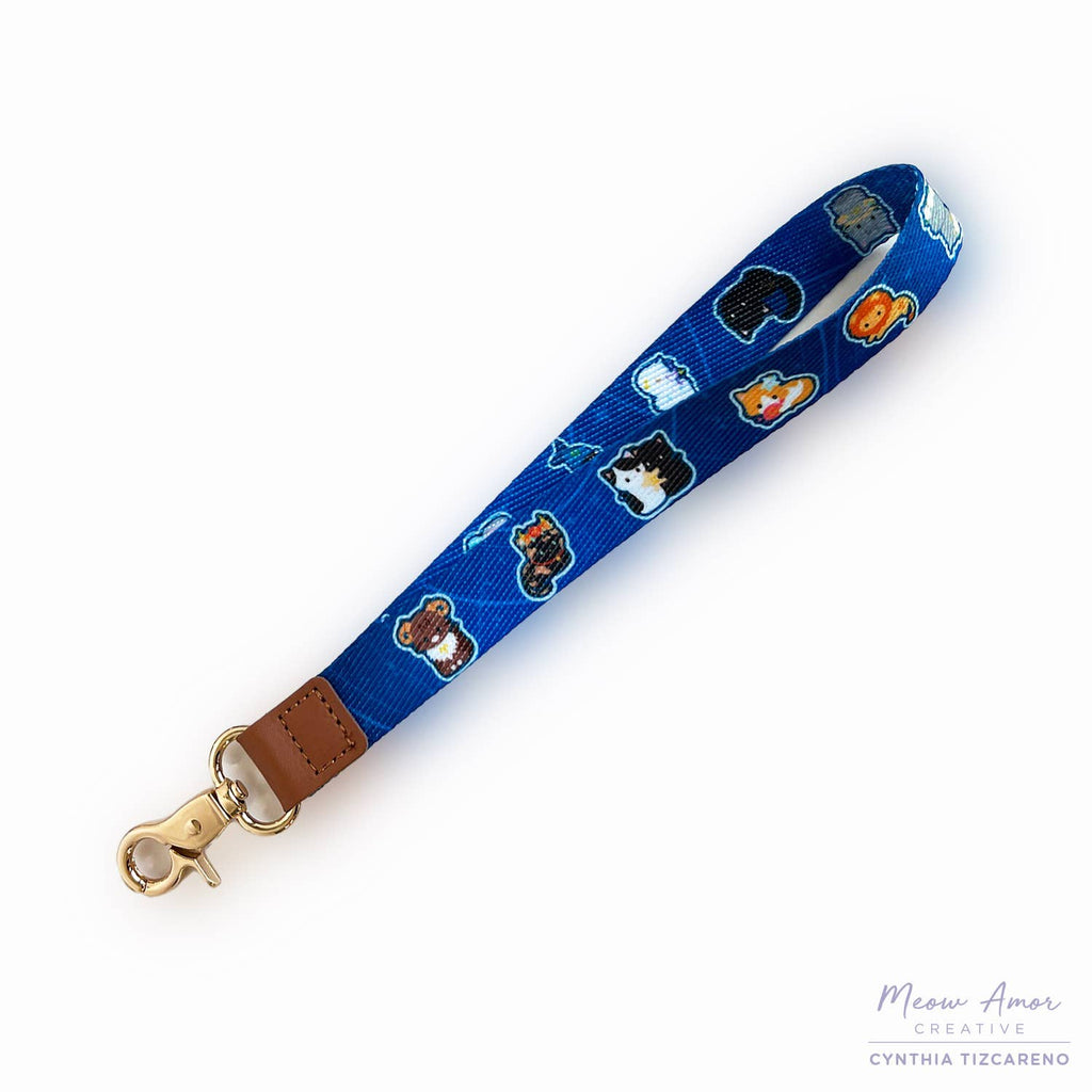 Blue lanyard with cat pattern and brown leather strap on a white background