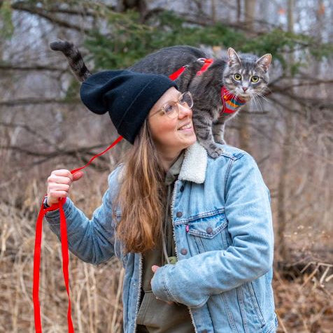 Woman with a cat on her shoulders outdoors